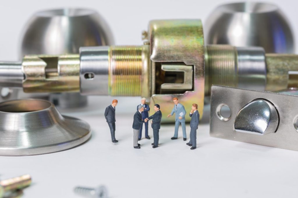 Personas en miniatura al lado de una cerradura gigante