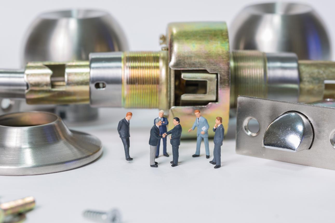 Personas en miniatura al lado de una cerradura gigante